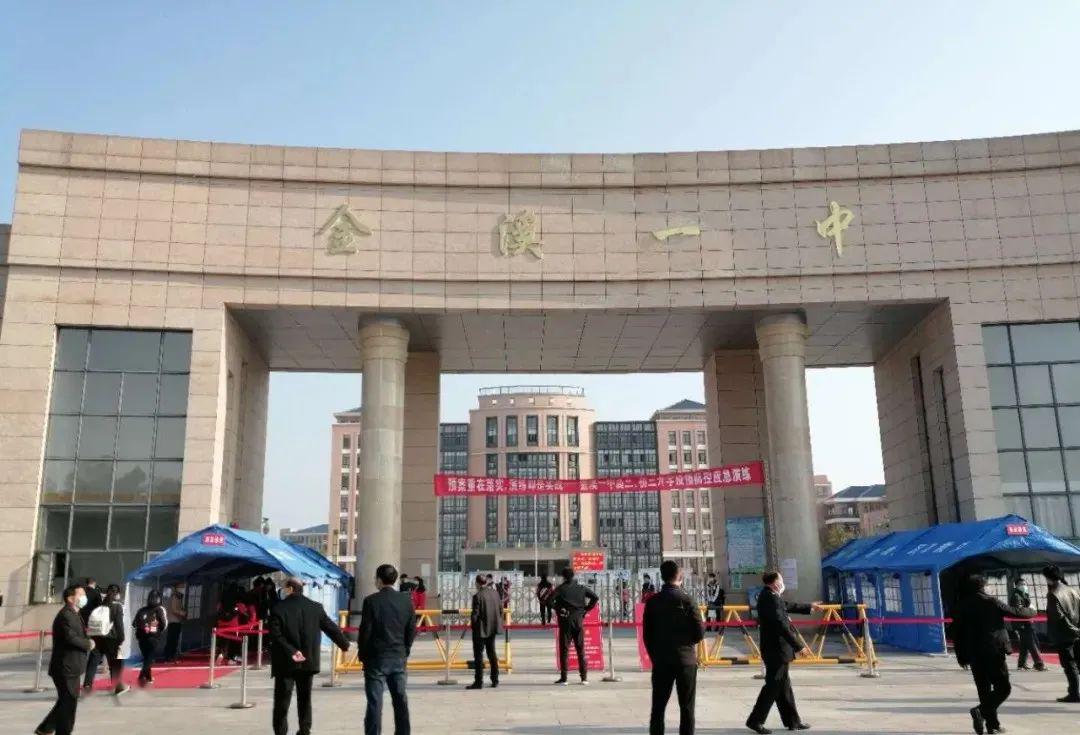 在金溪一中校门口,同学们间隔一米,分别从校门两侧有序进入校园,并在