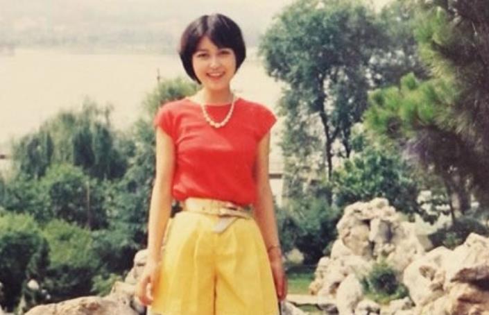 80年代中国女孩历史老照片:一个穿着艳丽衣服的短发美女在公园里留影