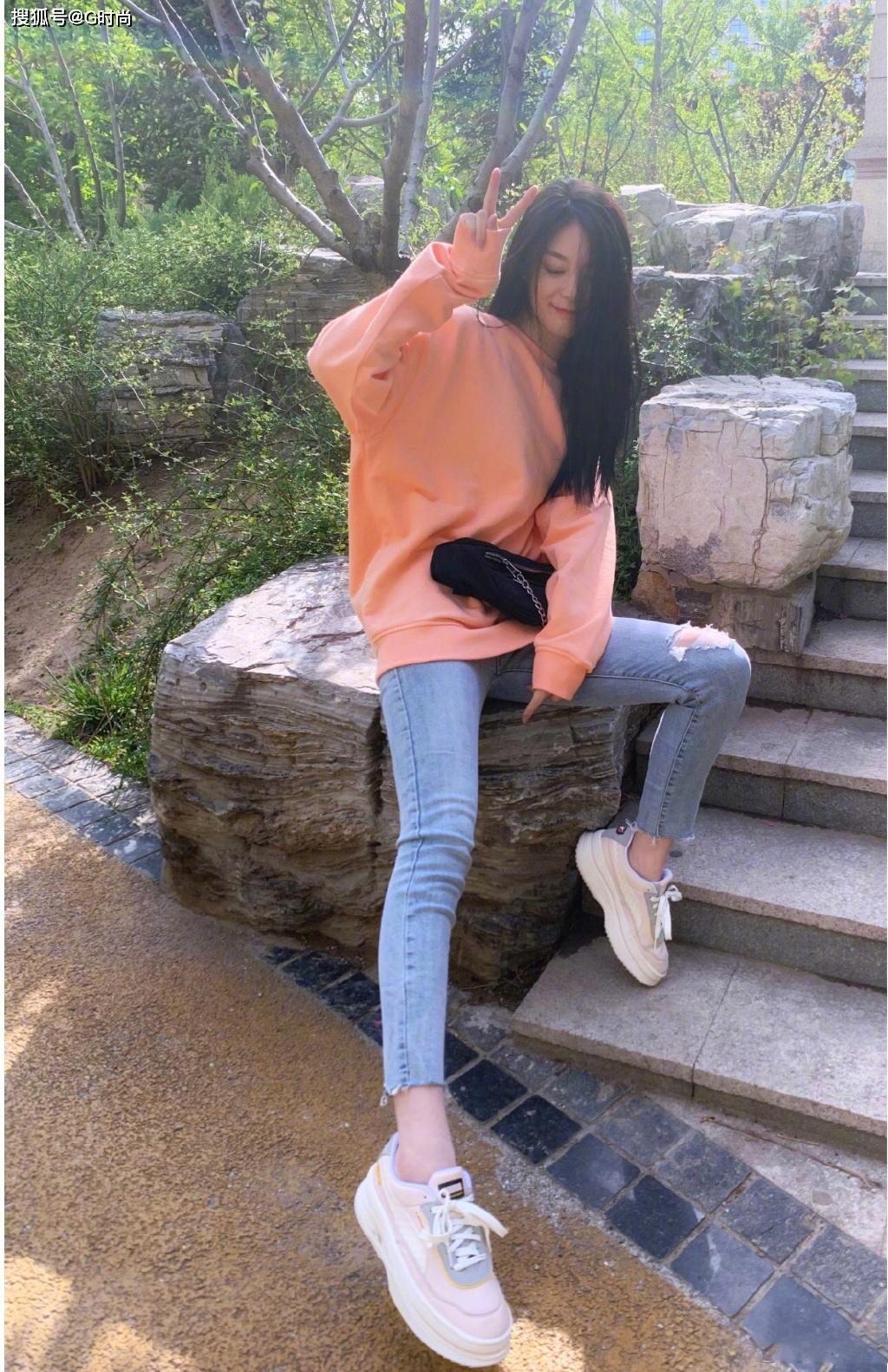 傅菁身着奶油橘色卫衣配浅色破洞牛仔裤 清新可人