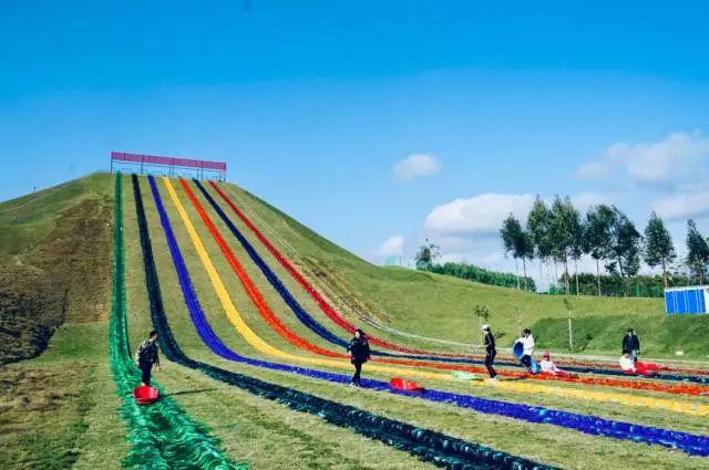 葱郁的草地,湛蓝的天空  映着五彩斑斓的彩虹滑道 轨道滑草