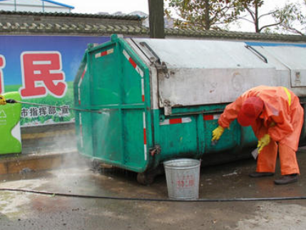 环卫工人对垃圾车消毒