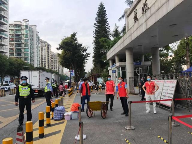 一大早,黄岐中学教职工在学校门口准备迎接返校学生