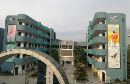 贵阳市第十二中学在学校教学楼外墙上新增了壁画,广场新建了花园,运动