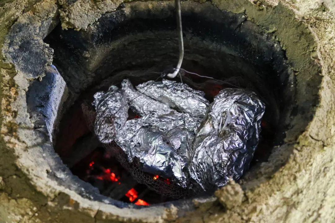 放入 荔枝柴火炭炉中,火候相当充足 烤出来的窑鸡也风味十足!