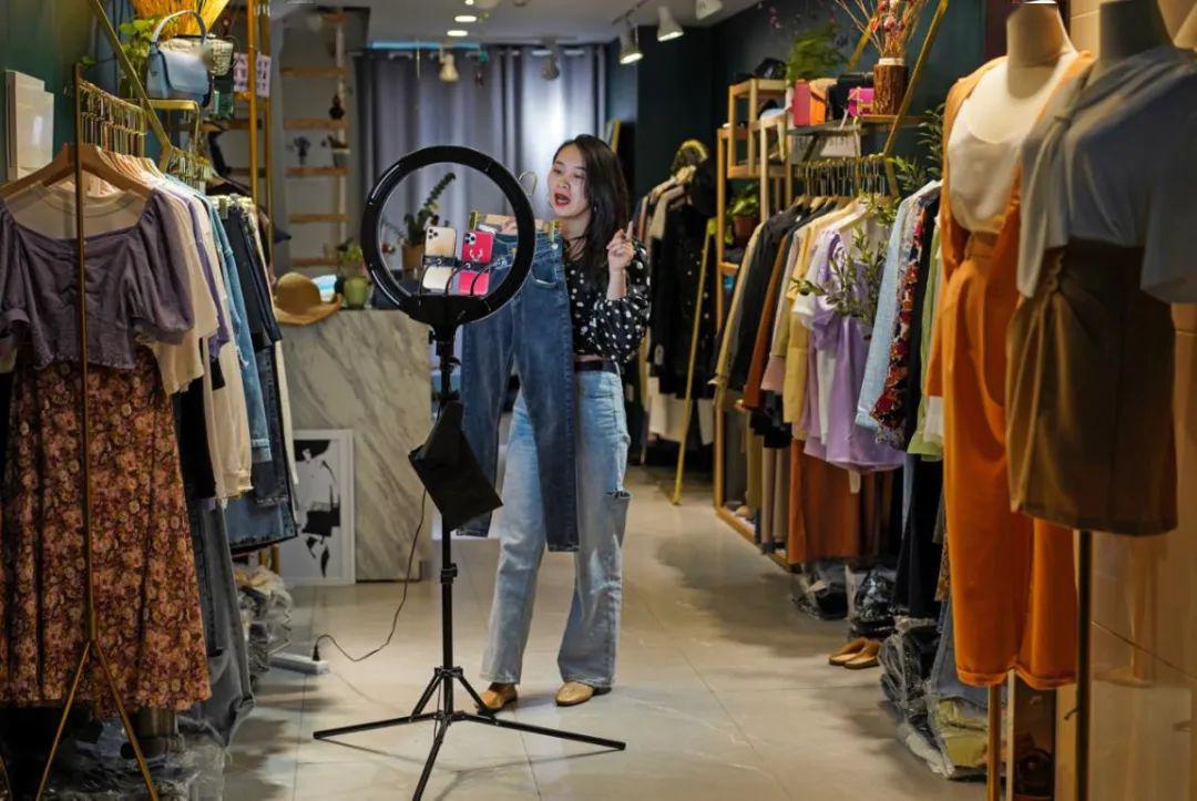 花果园国际中心1号楼,一名服装店店主在店内进行直播卖货