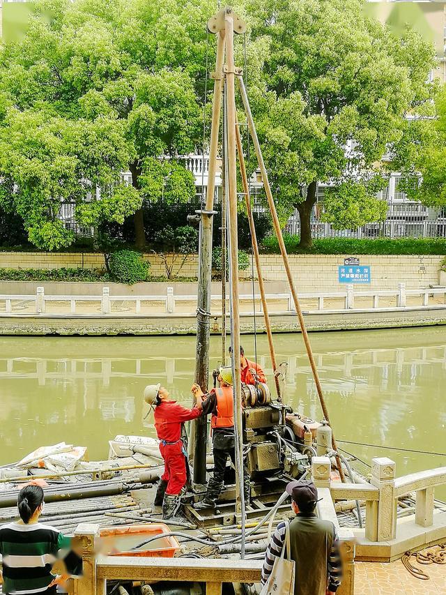 实拍五一节奋战在河道上的打桩工人