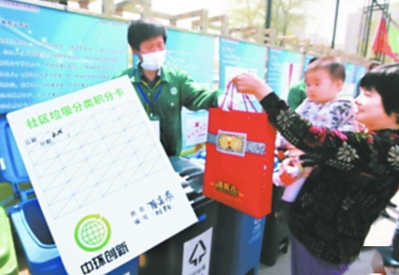 2011年,市民陈女士用"社区垃圾分类积分卡"交分类垃圾.
