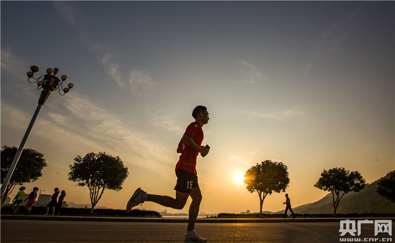 5月4日清晨,在江西省九江市都昌县南山公园,晨练者迎着朝阳跑步