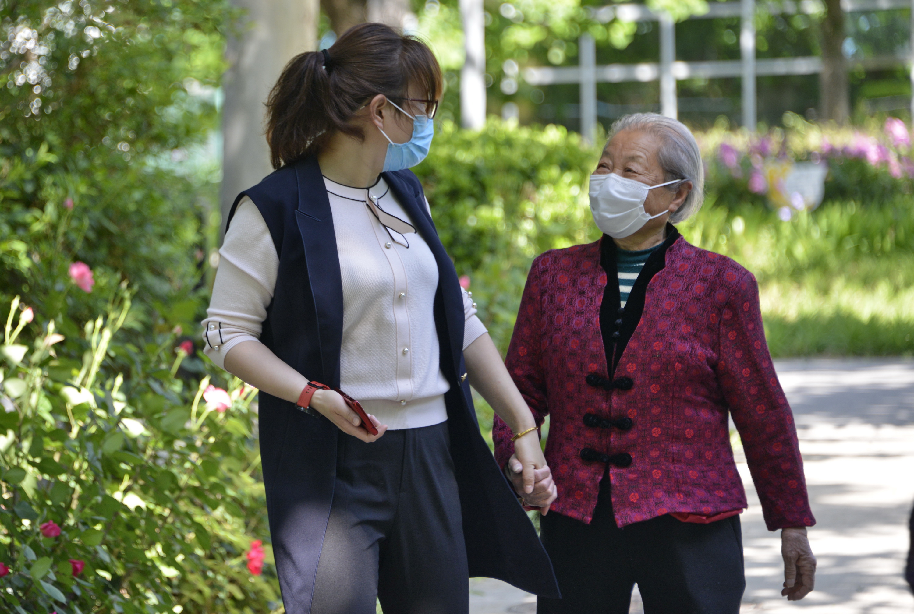 5月11日,工作人员在院区内陪老人散步.