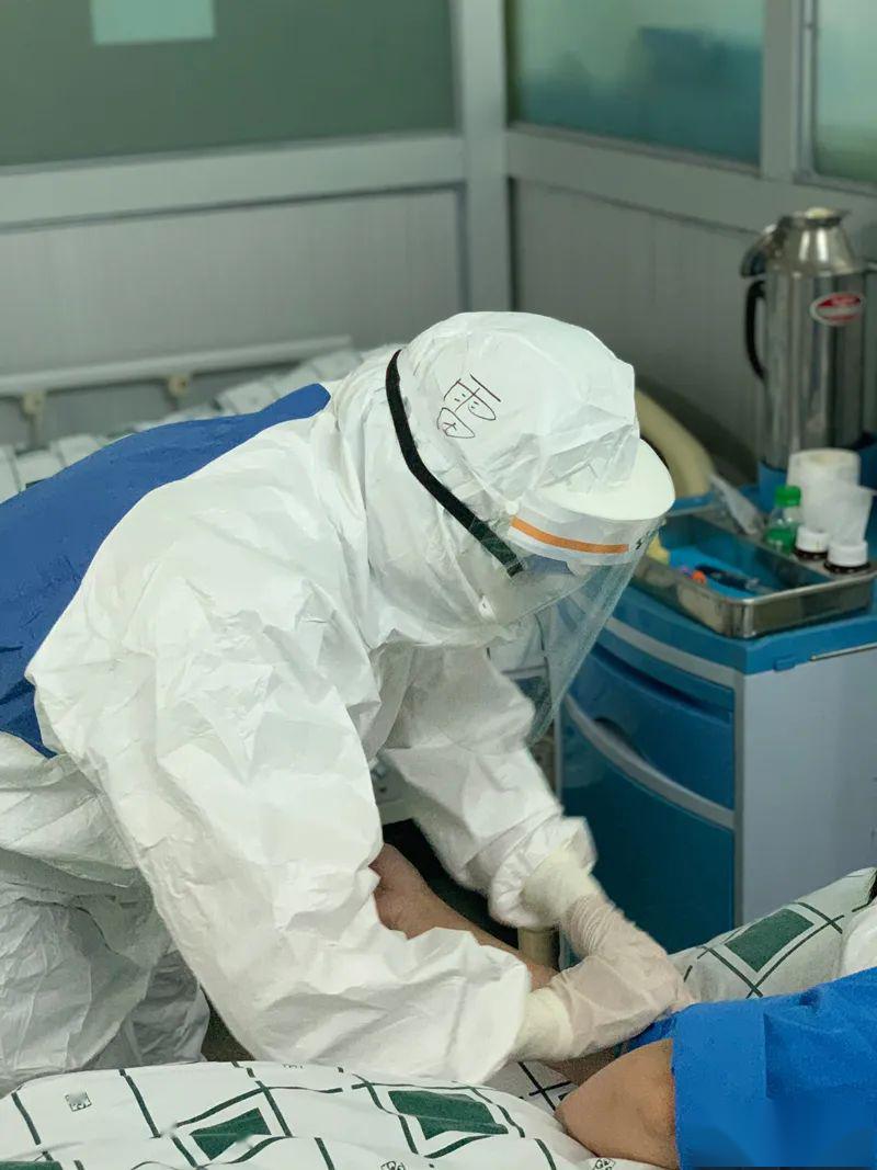 疫情期间,身着防护服的雷声秋在发热门诊留观室给一位发热留观患者