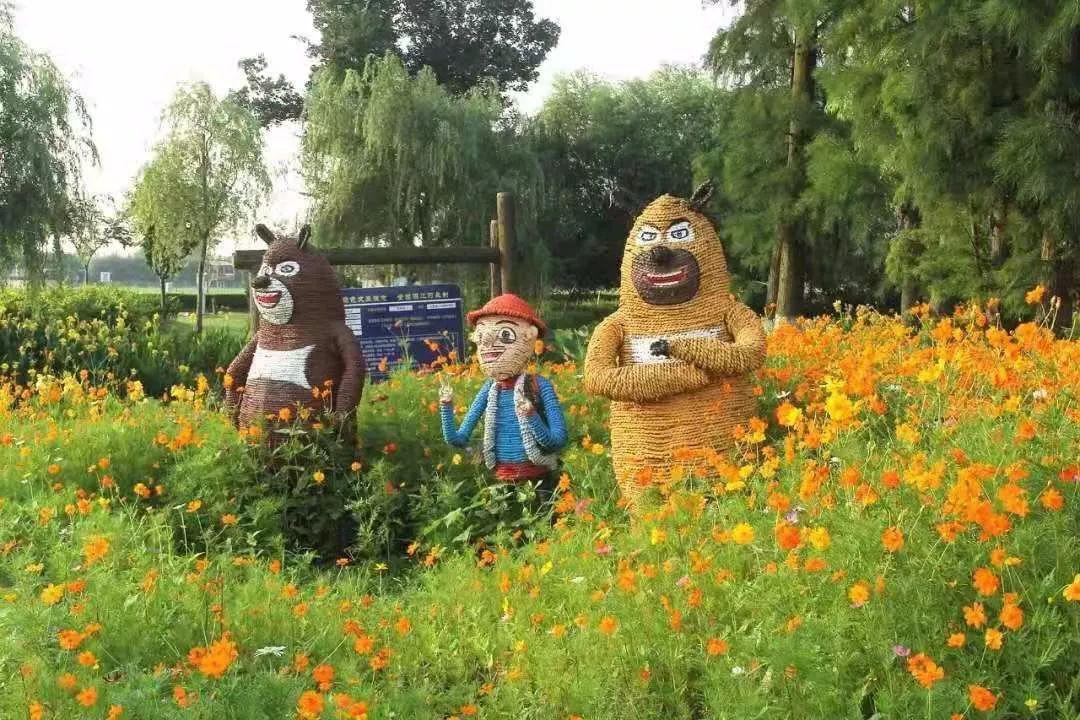 村道两边的各色鲜花开得正艳,稻草扎成的十二生肖,小猪佩奇给乡村增添