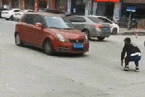东莞一男子多次用头撞向小轿车.