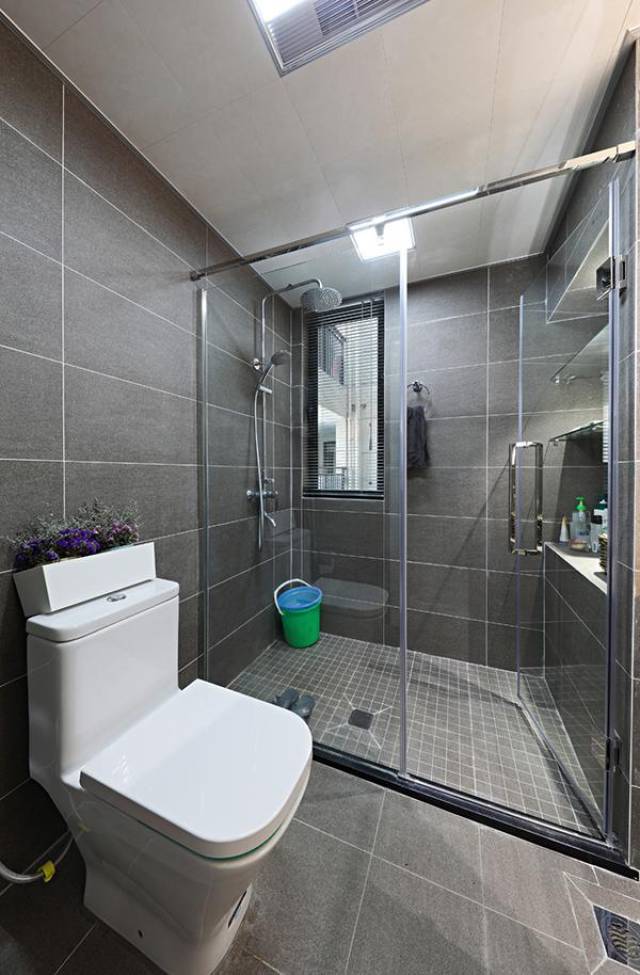 卫生间看着也挺时尚的,采用了灰色的砖面和白色的美缝结合,淋浴房考虑
