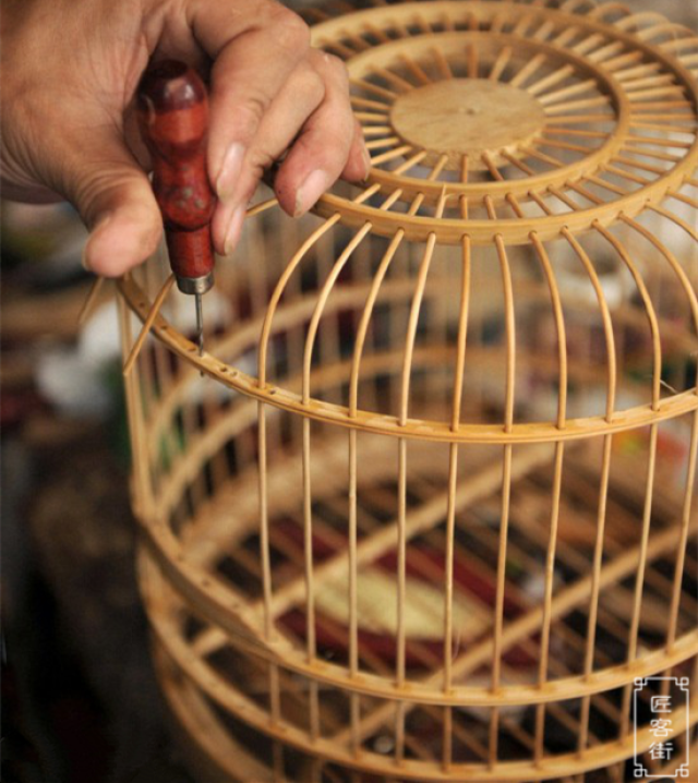 肖洪明制作的鸟笼非常经久耐用, 精细的每根穿孔竹签他都要上胶固定.