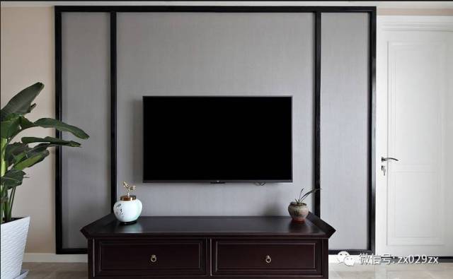 电视墙局部木质线条勾勒,灰色壁纸铺贴,右侧是次卧的门《电视墙上有