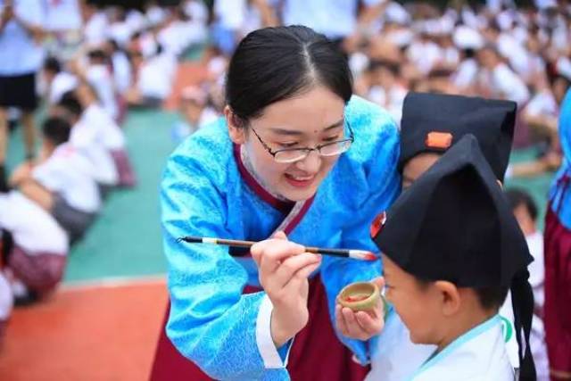 一年级老师给孩子眉心点朱砂,寓意为"朱砂启智"