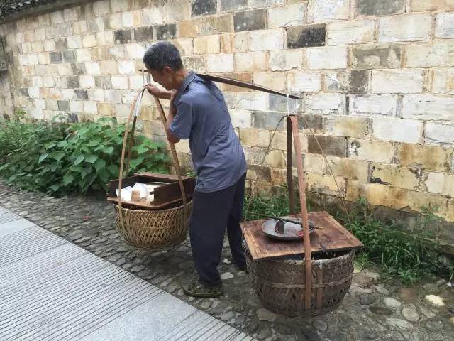 在自家做豆腐的汪长发老人挑着担子在村里叫卖 看到汪爷爷的豆腐摊