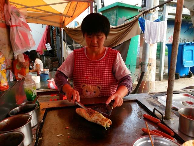 这家鸡蛋饼的摊位就在菜场入口处,有煎饼,杂粮饼,手抓饼等很多种类,手