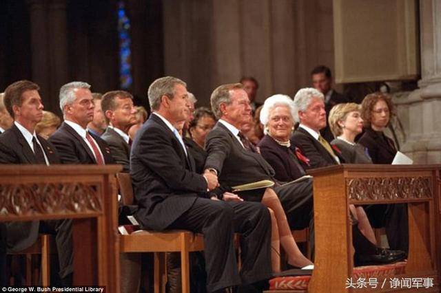 图为教堂中小布什抓着父亲布什的手,还可看到一排的克林顿,希拉里