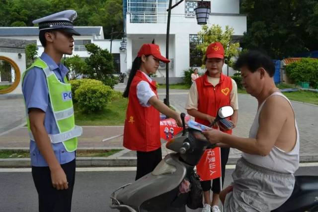 志愿者向过往群众和司机发放交通安全知识宣传册 策划:刘森冰 编稿