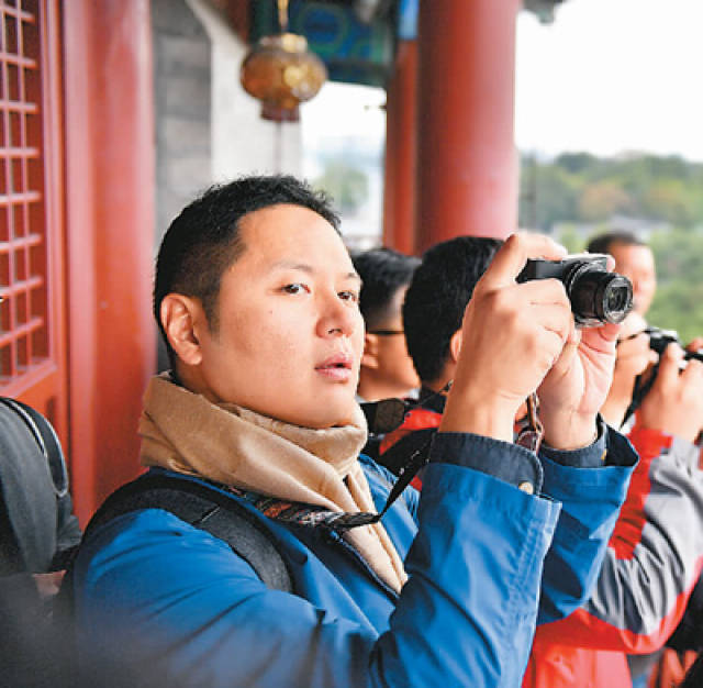 胡庆明摄(人民视觉)10月16日,外国记者在十九大新闻中心拍照留影.