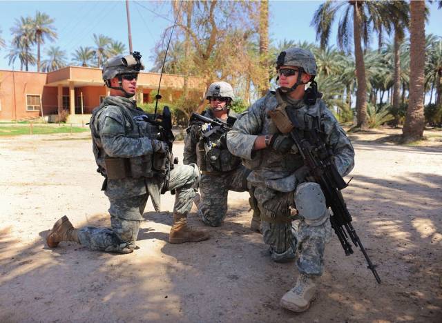 美国陆军第1步兵师3名士兵在伊拉克城市阿布扎比附近的一个农场执行