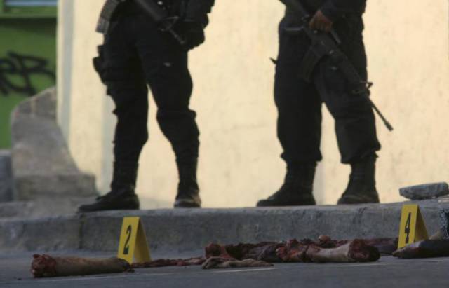 墨西哥警察警戒在被碎尸街头的死者尸身旁,尸身碎块被摆成"死亡圣神