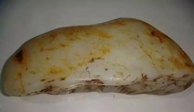 这是一个大化籽料,产自广西大化,有透闪石的成分,但玉,石共生,与平常