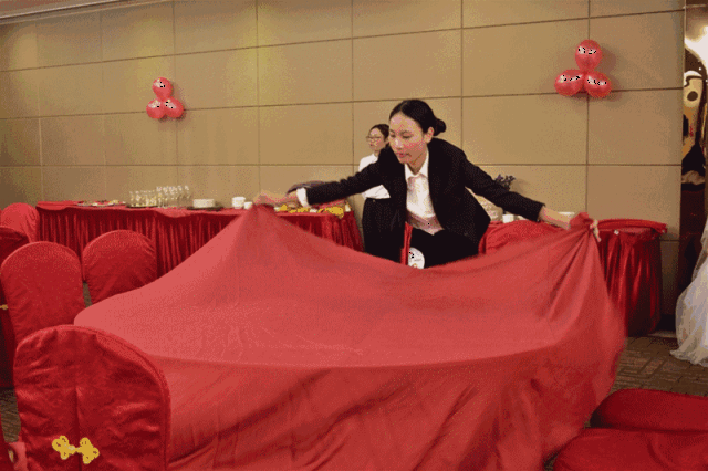 选手们依次铺桌布,放碗碟,酒杯,折好餐巾,然后细心整理好整个桌面的