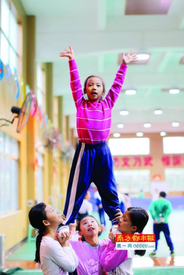 12月6日,佛山市元甲学校礼堂,学生们在练习抛接,托举等啦啦操动作.