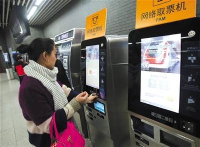 昨日,地铁南锣鼓巷站,一位市民用手机取票.新京报记者 王贵彬