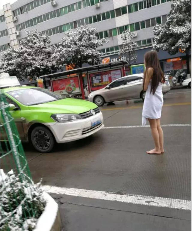 1月4日,大雪过后的汉中街头惊现一裹着浴巾的赤脚女子在寒风中瑟瑟