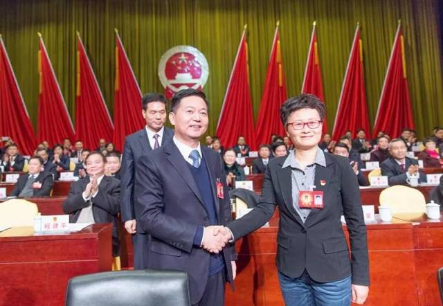 图为:市委书记马承祖与新任命的市监察委员会主任杨文英握手