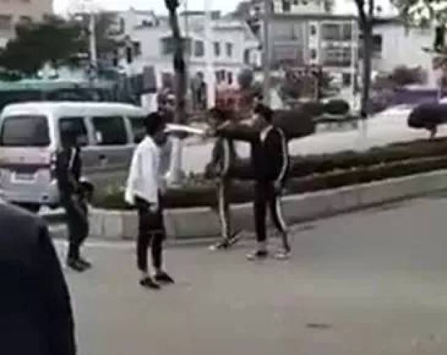 ▼ 其中一名身穿黑色上衣的青年 右手还拿着一把明晃晃的刀 ▼ 打架