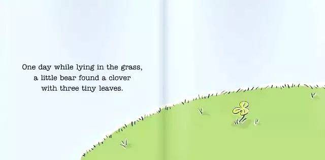 day while lying in the grass,a little bear found   clover with
