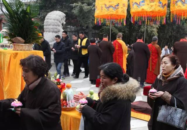 百名青衣居士和善信游客手捧莲花灯,步行至山隐寺.