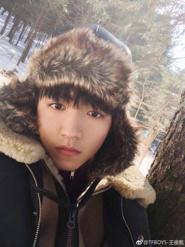 王俊凯身穿大棉袄,头戴网红款"保庆帽",皑皑白雪下深邃撩人的眼神