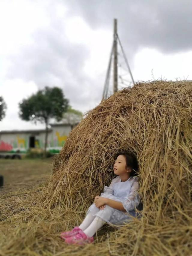 玩累了,小朋友可以靠着草垛上枕着手休息.