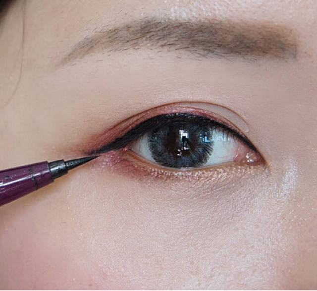 第八步:用眼线液笔沿着睫毛根部画出一条细长的黑色眼线,眼尾处跟着