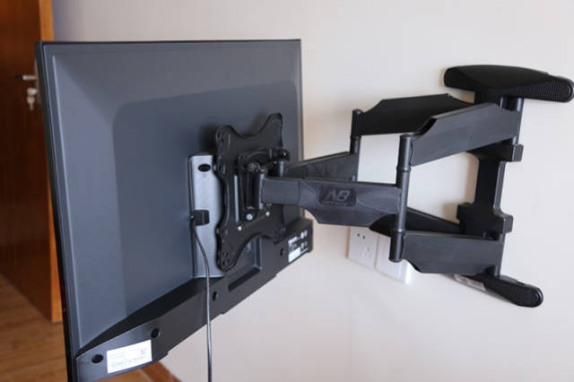用电视支架配套的螺丝将电视支架的板在电视背后固定,支架板和电视不