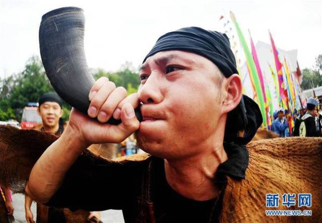 4月22日,一名壮族青年在吹牛角号,为布洛陀民俗文化旅游节助兴.