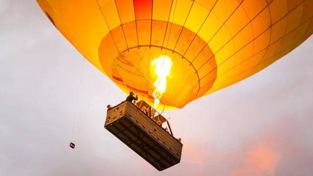 热气球飞行的原理就是喷火装置把空气烤热,里面空气密度小就能飞起来.