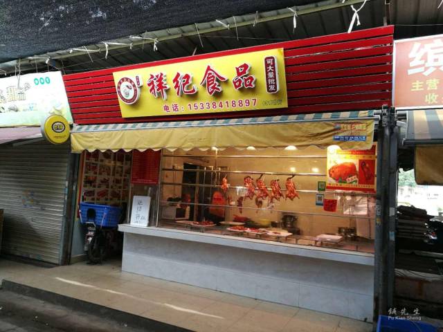 本店是一家正在经营的烧腊店【祥记食品】,隔壁有家鱼店,门前是市场