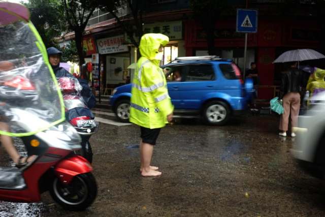 因鞋子湿透很不方便,射洪一女交警光脚执勤