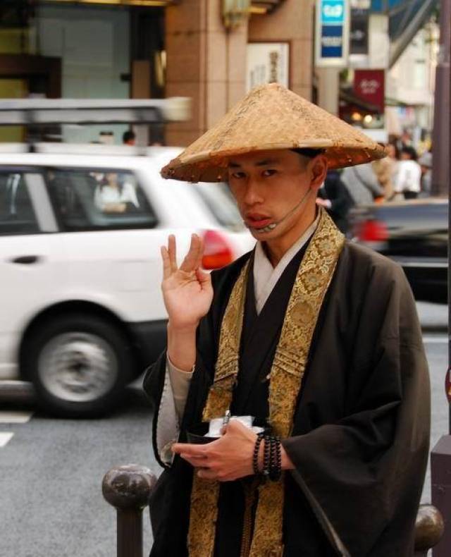 东京都街头一个戴斗笠的日本僧人.