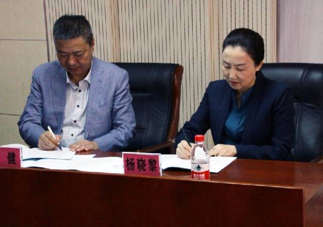 何健和河西学院附属张掖人民副院长杨晓黎签约并接受医联体牌匾并合影