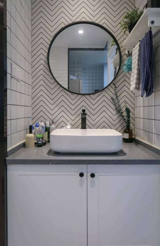 洗手盆采用较为高档的台上盆,搭配一个黑框园镜,在波浪纹的墙砖搭配