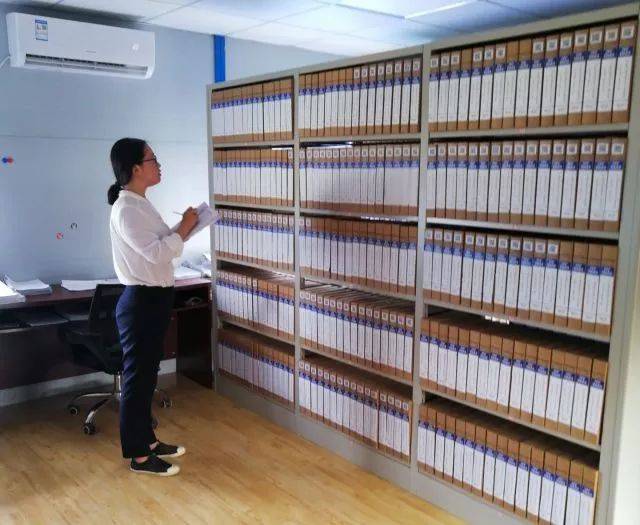 长沙市公证处工作人员造访土木公司档案室,与档案人冯秀萍(右)核实