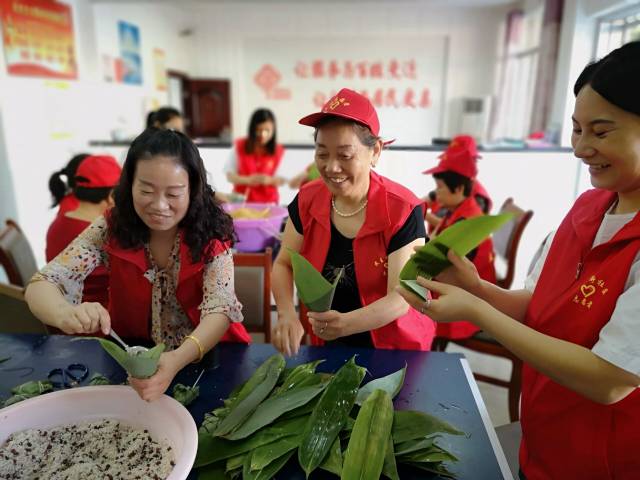 图为活动现场,社区志愿者,居民代表和社区干部一起包粽子.