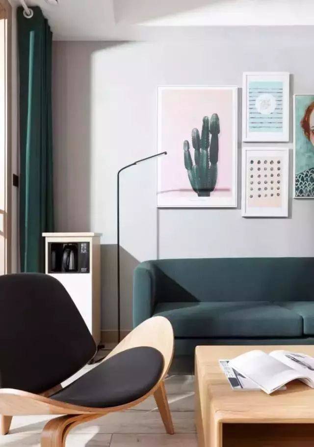 客厅浅灰色背景墙搭配墨绿色沙发,挂几幅抽象现代画,算不上惊艳